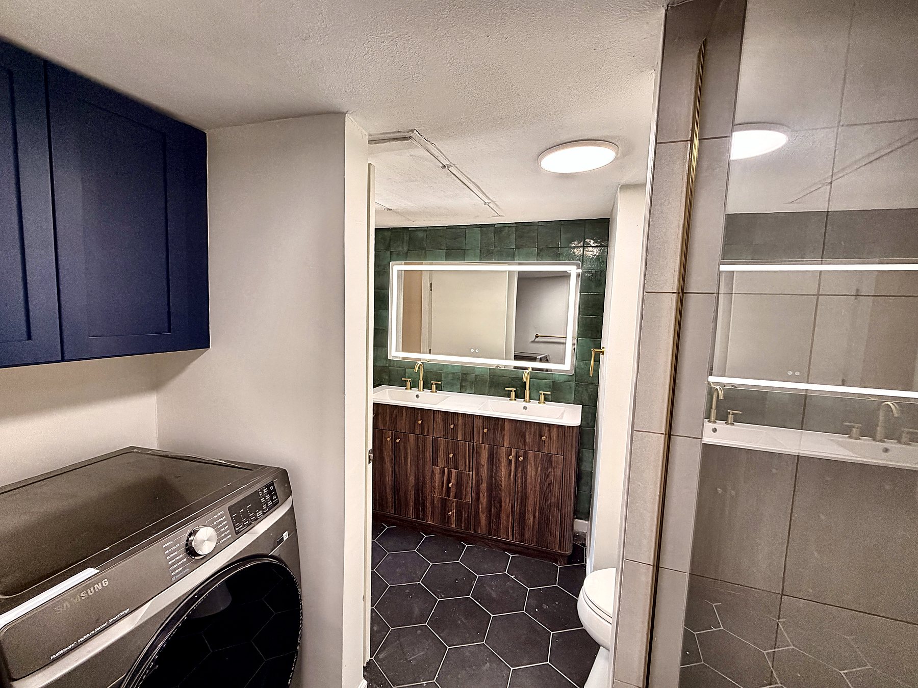 In-unit Samsung washer and dryer beside the main bathroom